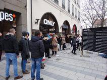 Menschen in der Innenstadt vor einer Tafel